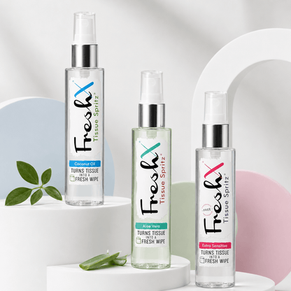 Three bottles of FreshX Tissue Spritz on a white background with a plant leaf and aloe vera.