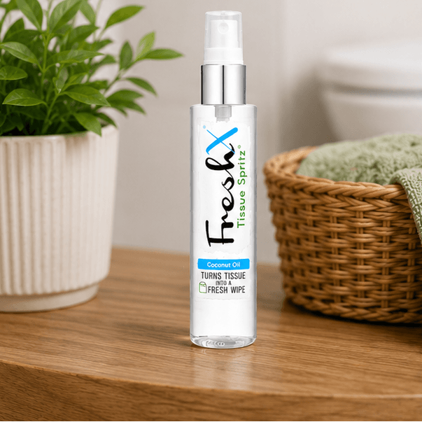 Bottle of FreshX Tissue Spritz on a wooden surface with a plant and basket in the background