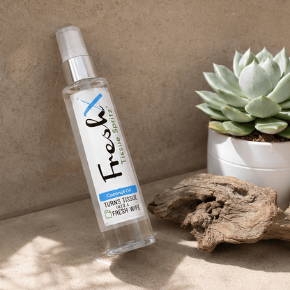 FreshX tissue spray bottle with a succulent plant and wooden log on a neutral background
