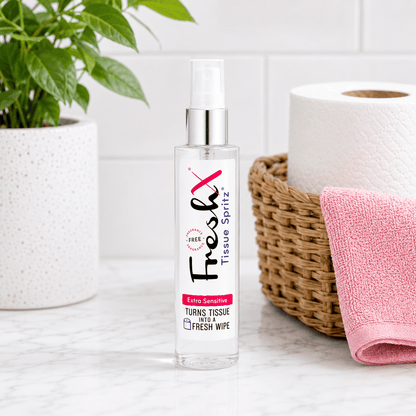 FreshX Tissue Spritz bottle on a bathroom counter with tissue paper and basket in the background.