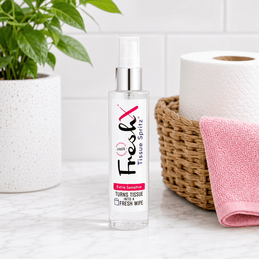FreshX Tissue Spritz bottle on a bathroom counter with tissue paper and basket in the background.